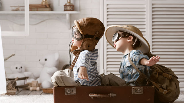 Kids playing in a suitcase pretending its a plane