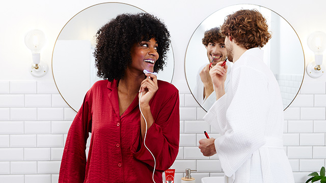 Young woman and man using led whitening kit