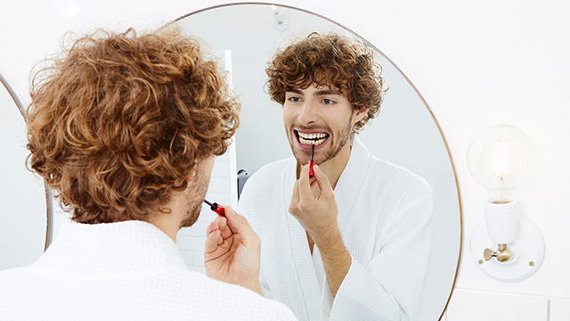 Young man using whitening pen
